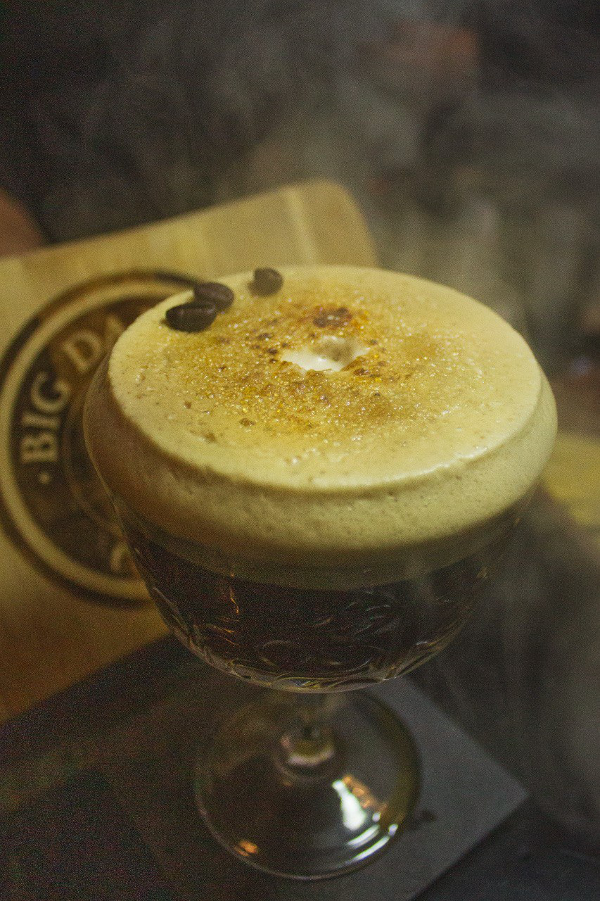 Cocktail al caffè con schiuma e chicchi di caffè in una coppa
